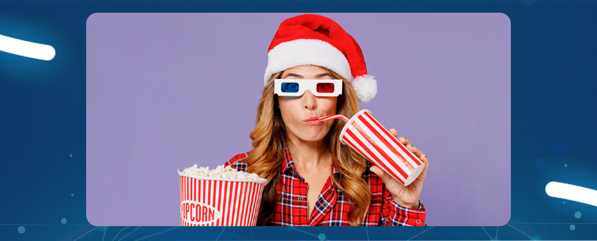 dziewczyna w czapce mikołaja i okularach do filmów 3D pije przez słomkę z kubka a w drugiej ręce trzyma popcorn