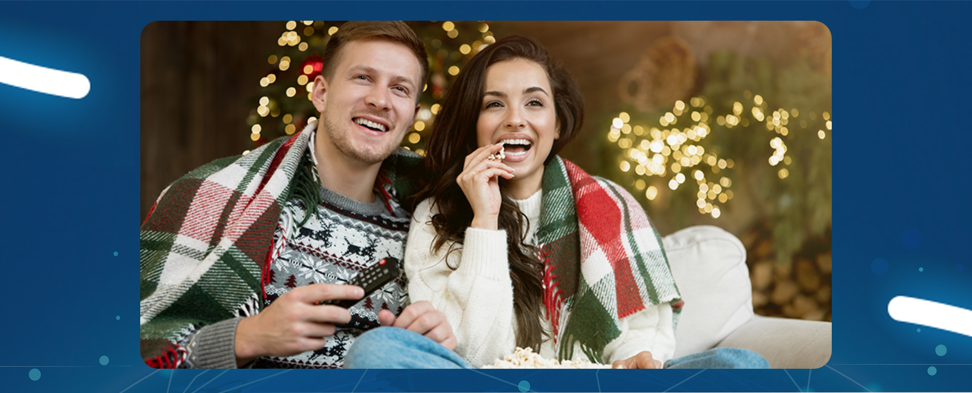 para siedzi na kanapie i oglądają telewizję w tle choinka