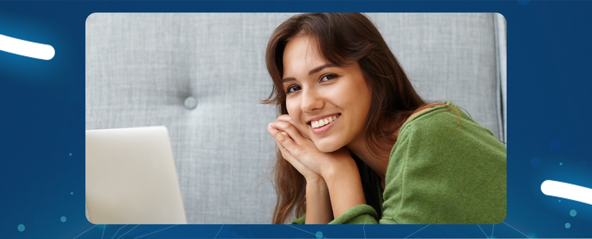 młoda uśmiechnięta dziewczyna leży na brzuchu przed laptopem