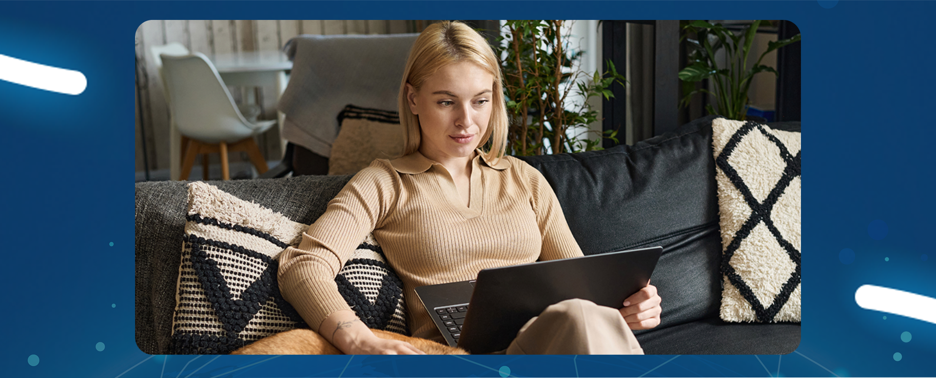 dziewczyna siedzi na kanapie z laptopem na kolanach